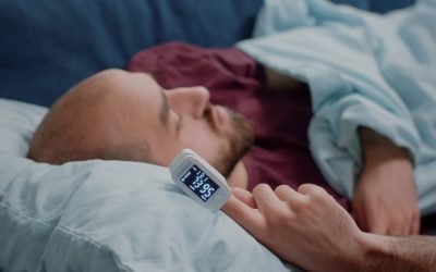 Close up of oximeter on hand of ill person resting while measuring oxygen saturation and pulse pressure to check virus symptoms. Sick adult using device for healthcare treatment